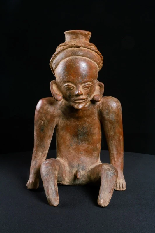 Vasija precolombina de cerámica de la cultura Tumaco–La Tolita, estilo Dos Quebradas, que representa una figura masculina con tocado ornamental y una pronunciada curvatura en la espalda (cifosis angular).